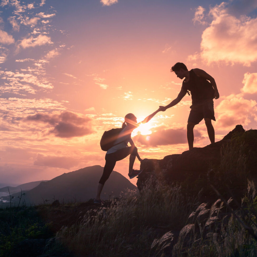 Helping hikers Hikers helping each other at sunset.
